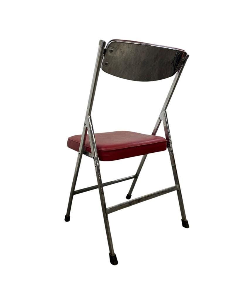 Vintage folding chair in red faux leather with a chrome frame.