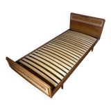 Vintage single bed made of rattan from the 1970s with a mattress.