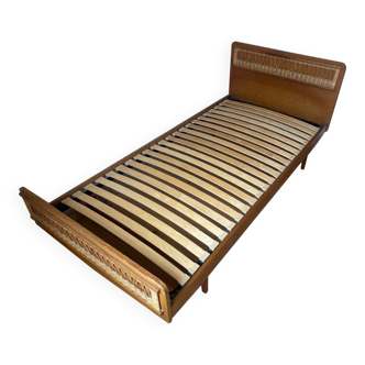Vintage single bed made of rattan from the 1970s with a mattress.
