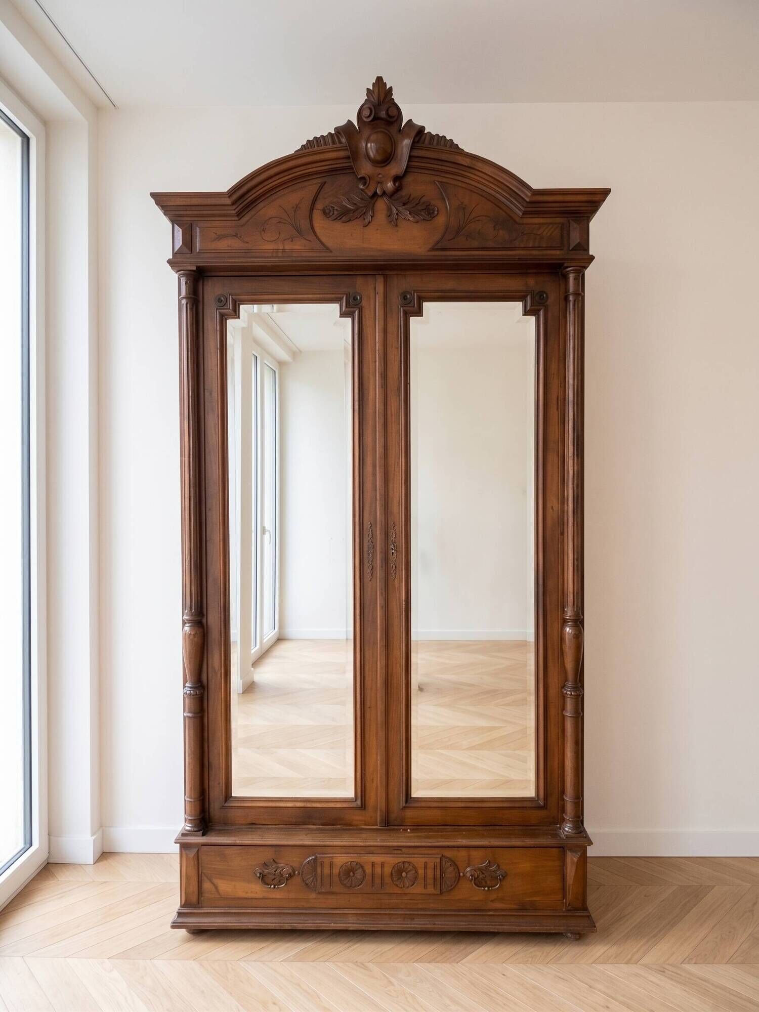 Antique walnut wardrobe with bevelled mirrors.