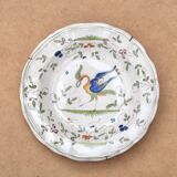 Hollow plate in Moustiers faience decorated with a bird, 19th century.