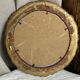 Round wooden mirror in golden colour.