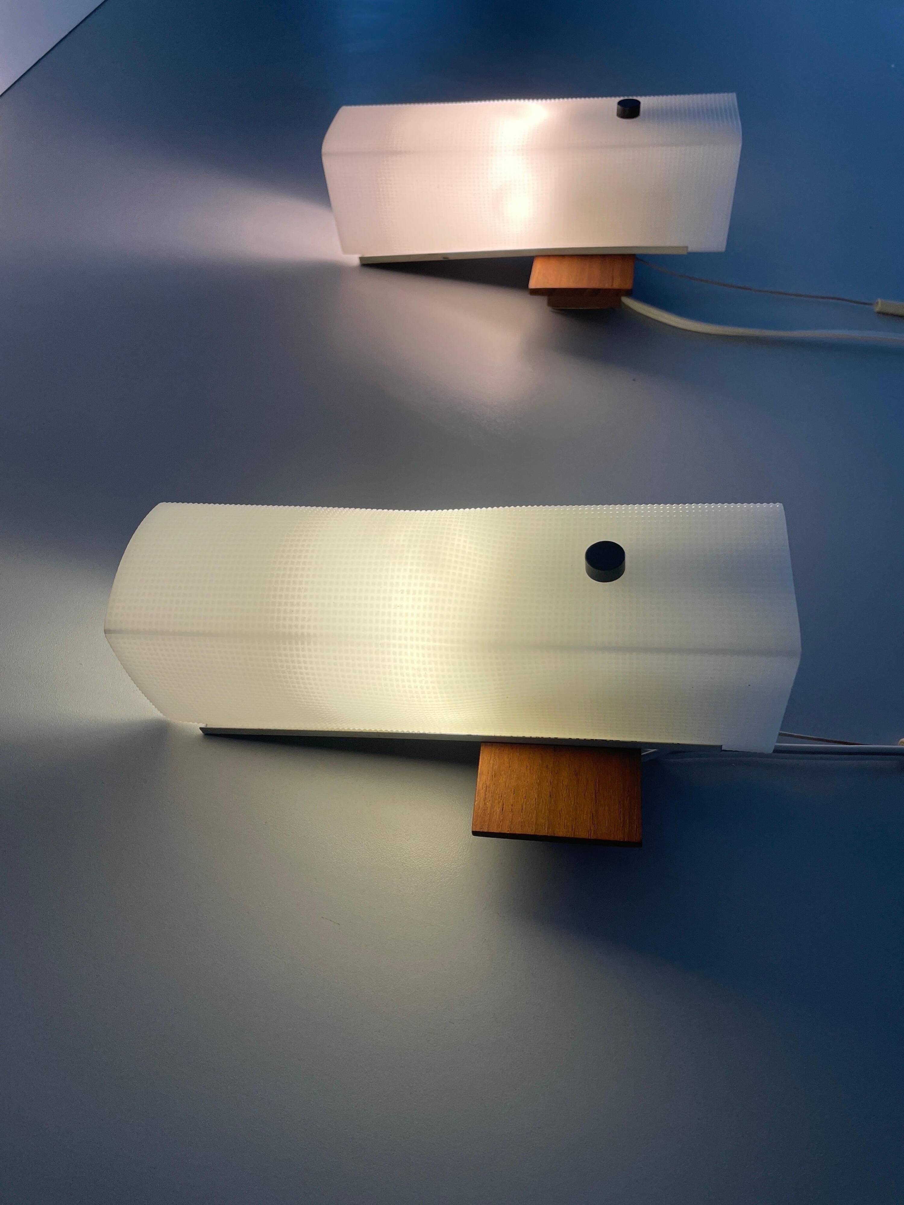 Mid-century wall lights in white plexiglass with a wooden base, 1960s, Germany.