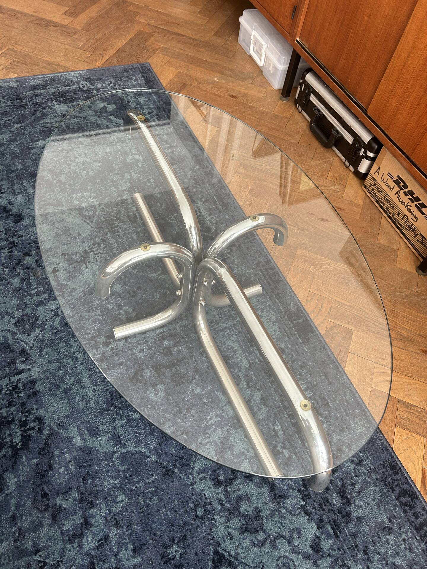 Oval glass coffee table with chrome legs, vintage 70s design.