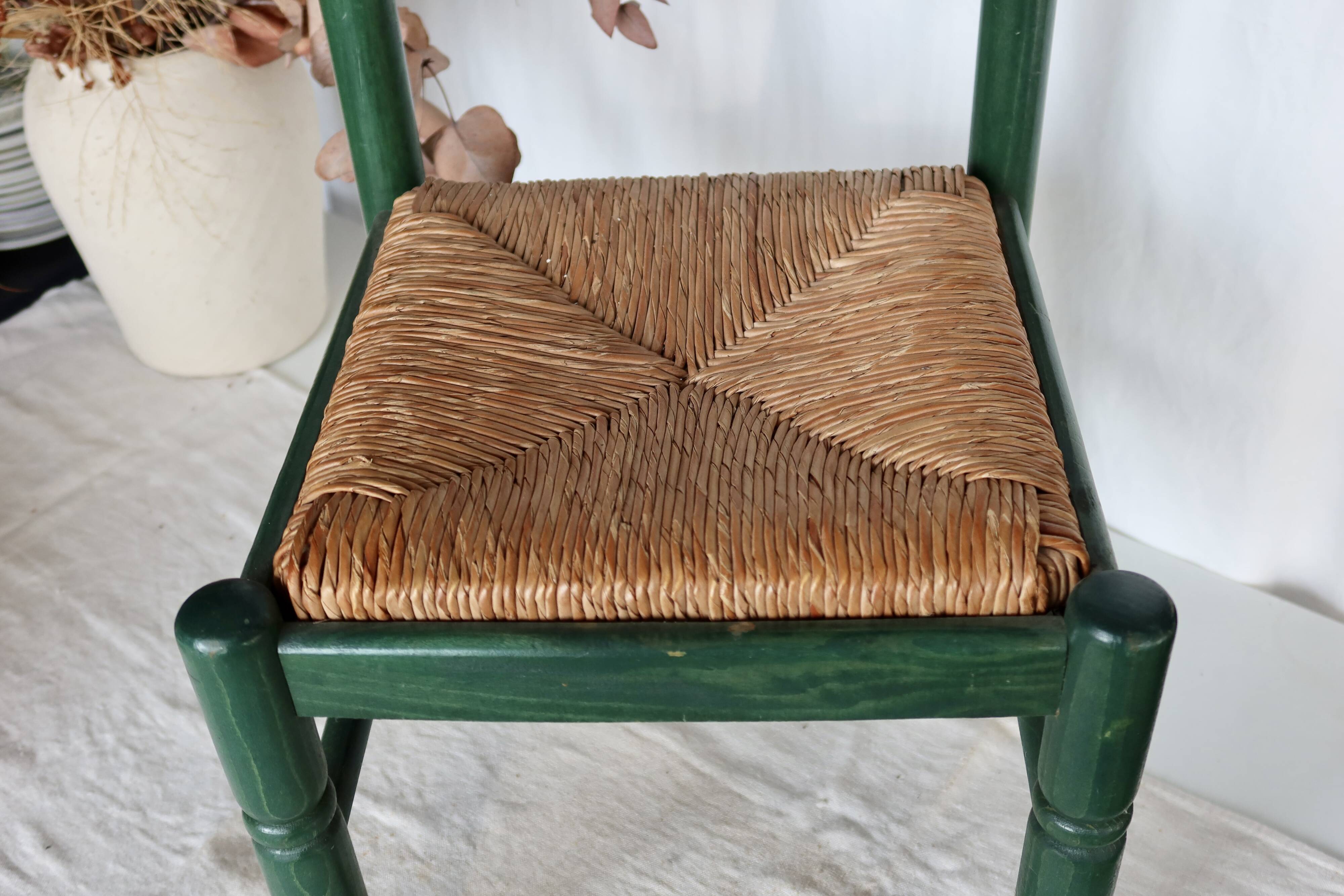 Vintage children's chair in green wood with a woven straw seat