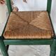 Vintage children's chair in green wood with a woven straw seat