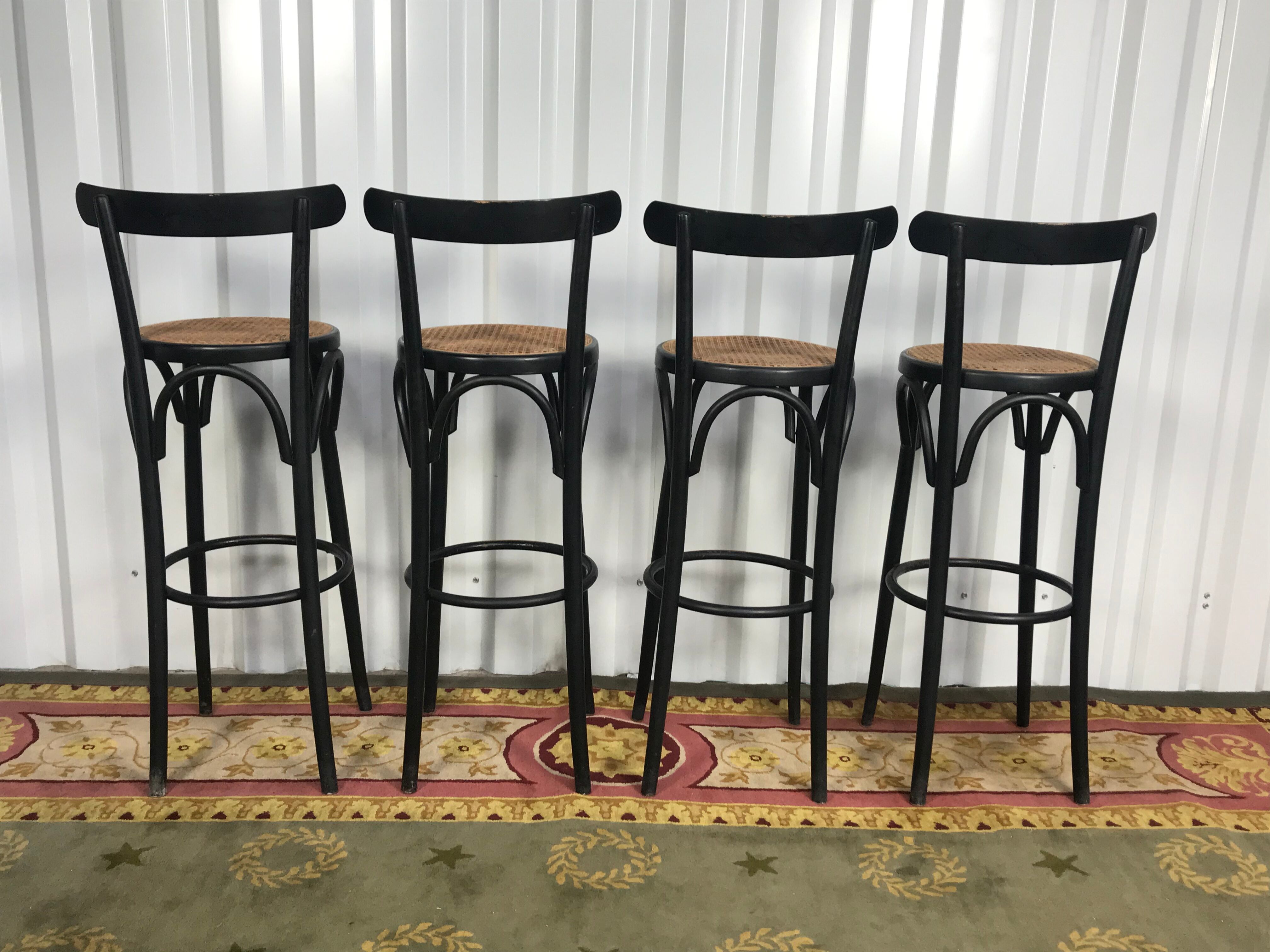 Suite de 4 tabourets de bar en cannage et bois noirci