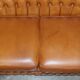 Small Chesterfield leather sofa with a high back.