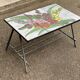 Vintage rectangular coffee table with ceramic inlaid flowers and steel.