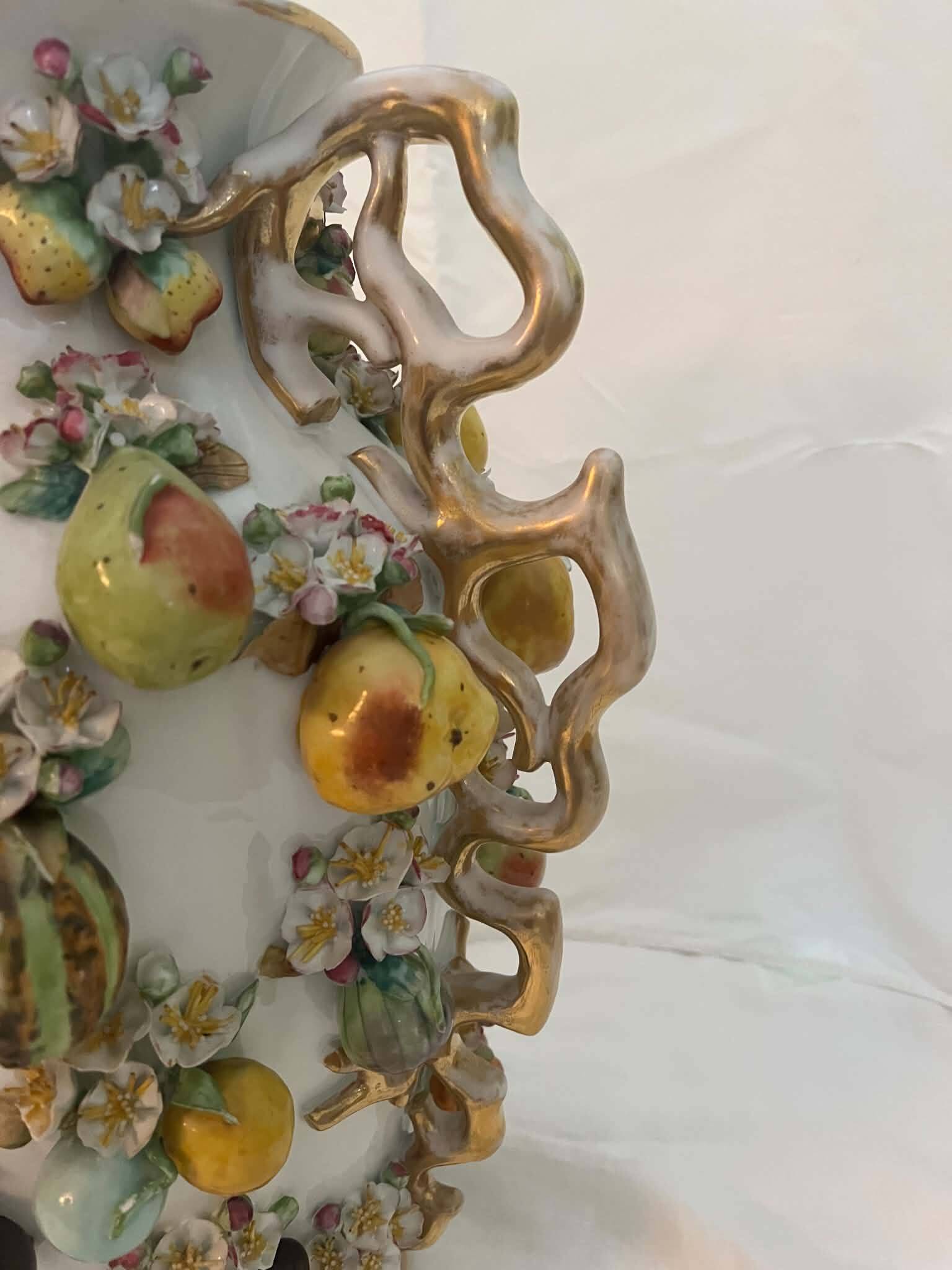Large antique vase with relief decorations of coloured fruits.