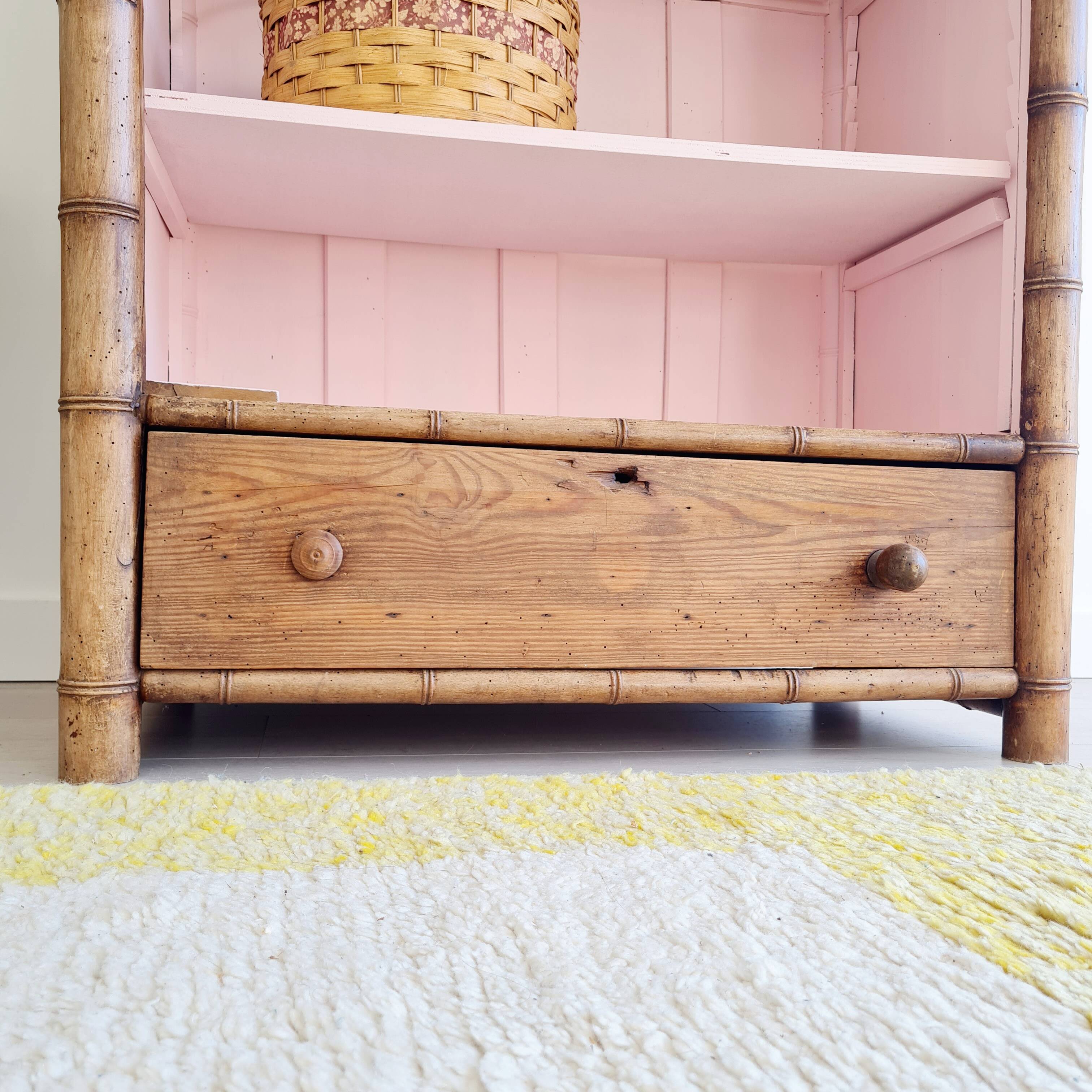 Library, old wooden cabinet imitating bamboo painted in pink