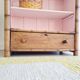 Library, old wooden cabinet imitating bamboo painted in pink