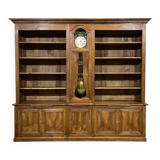 Library in walnut and oak from the early 20th century with its central clock.