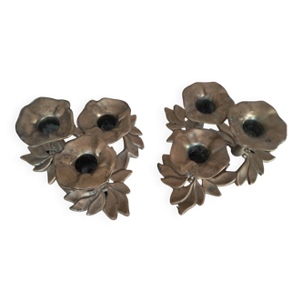 An antique pair of candlesticks with a floral design.