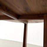 Modernist round table in solid elm, crossed legs.