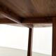 Modernist round table in solid elm, crossed legs.