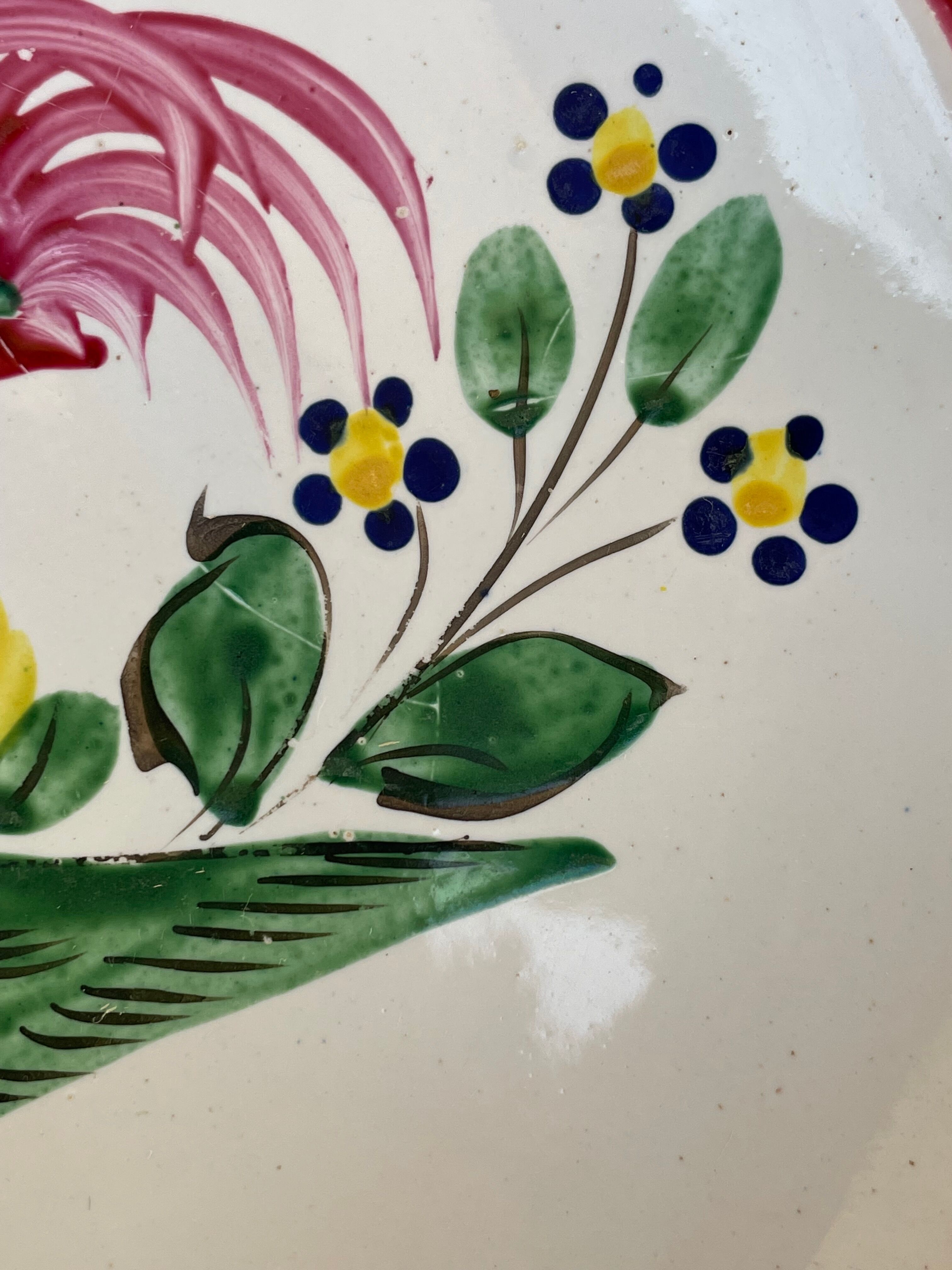 Antique plate with a flower and rooster pattern.