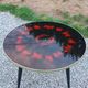 Vintage coffee table with glass top and tripod legs in blackened wood from the 1960s.