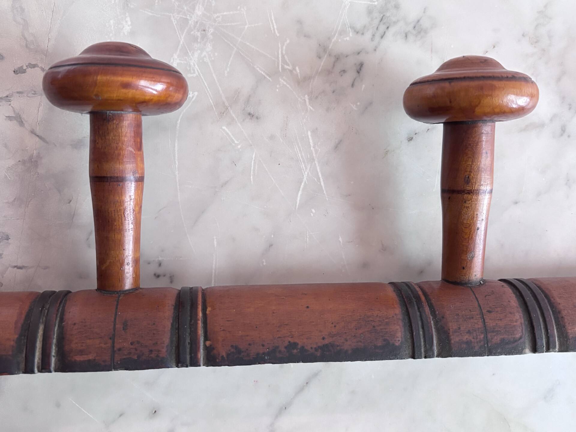 Wall-mounted coat rack with 8 turned wooden hooks in faux bamboo style.