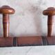 Wall-mounted coat rack with 8 turned wooden hooks in faux bamboo style.