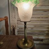 Small table lamp with a brass fish base and a tulip shade with green edges.