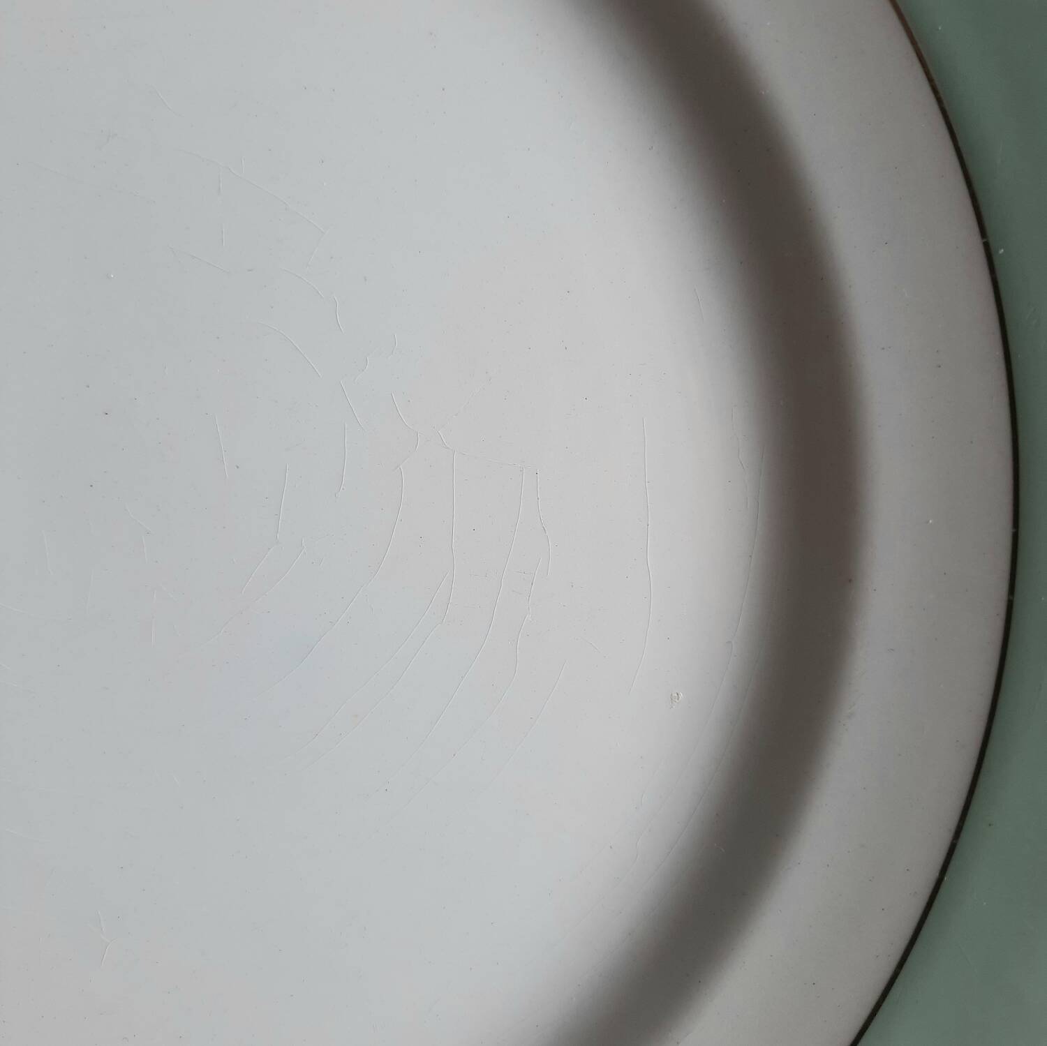Old mismatched earthenware dinner plates accompanied by a deep dish