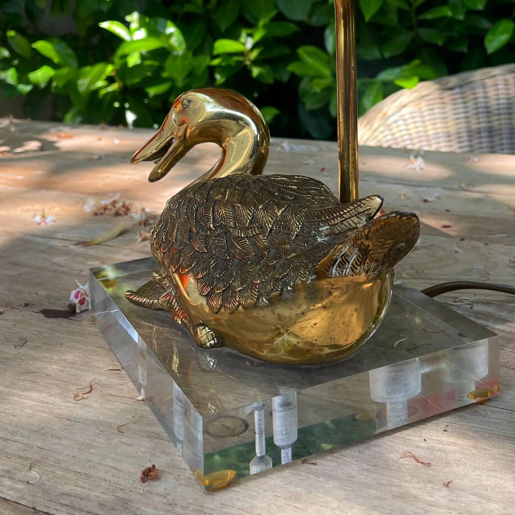 Vintage brass table lamp in the shape of a duck from the 1970s on an acrylic base.
