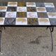 Vintage coffee table with black wrought iron and white tiles.