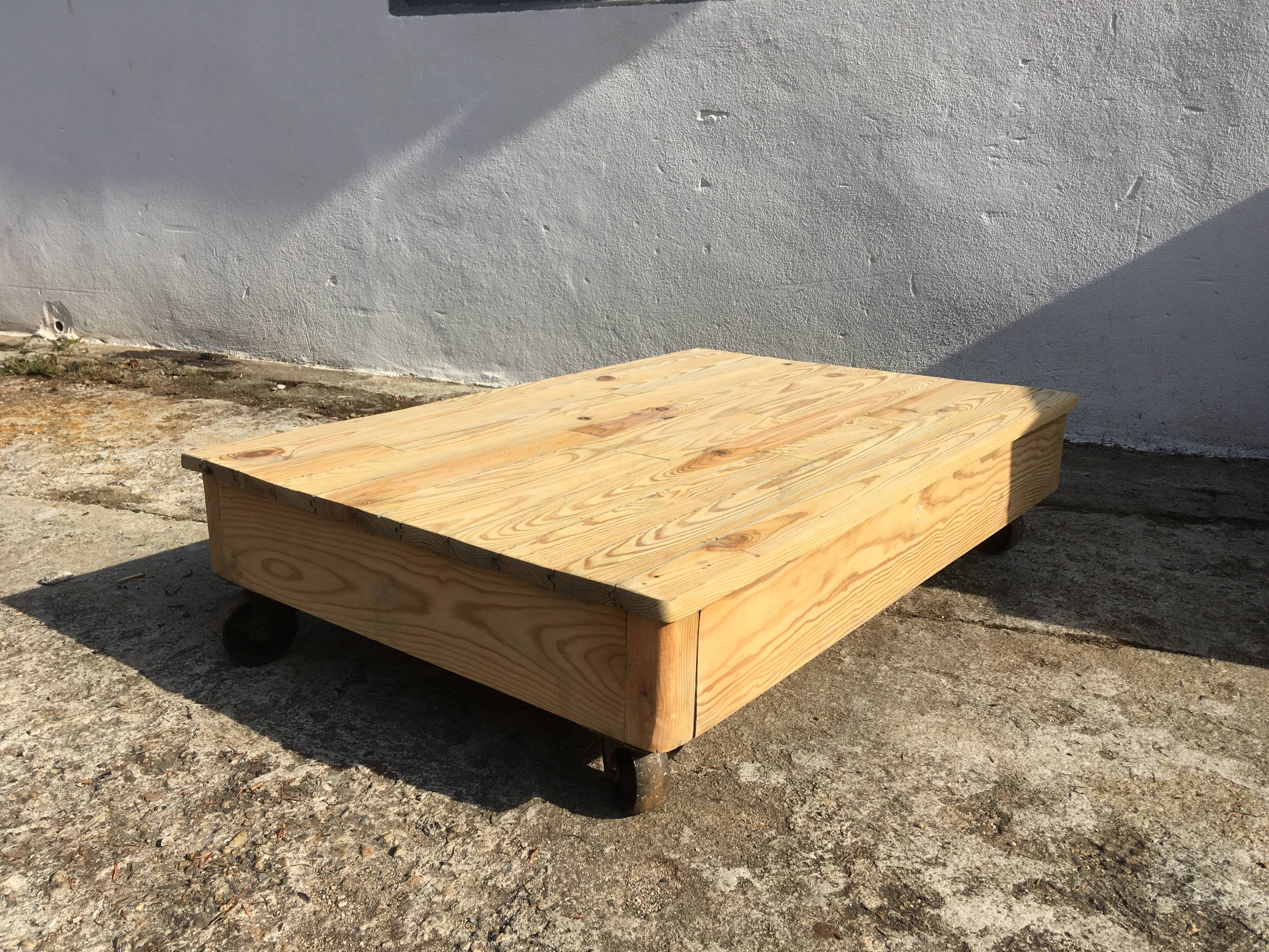Old wooden school platform bass table on metal wheels
