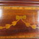 Antique English display cabinet. Marquetry with floral patterns and ribbons.