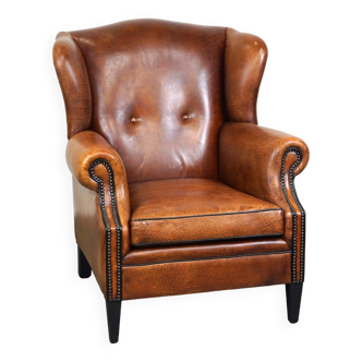 Fauteuil à oreilles en cuir de mouton, avec clous et passepoil noir