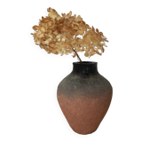 Terracotta vase with gradient of black faded to half on an earth-colored background