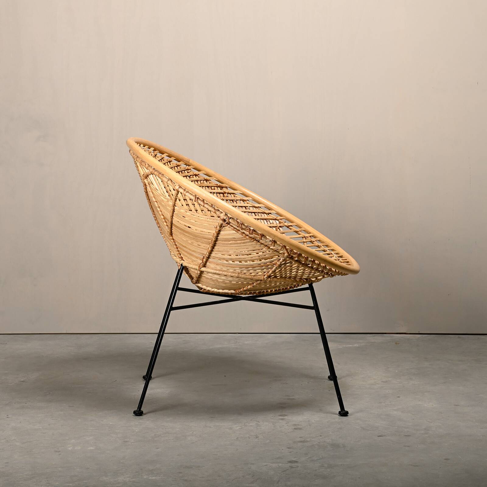 Round rattan lounge chair with black metal frame