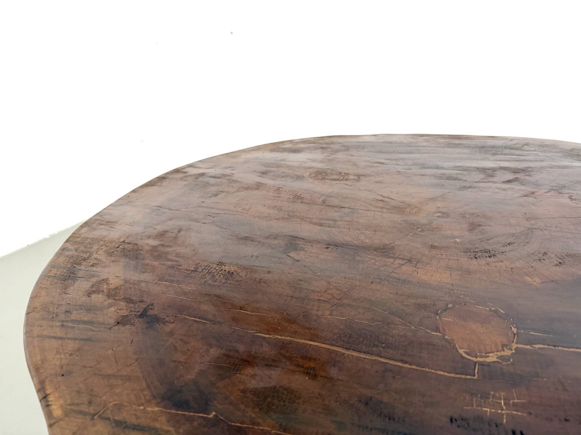 Brutalist coffee table in solid teak, monolithic slab, tripod base.
