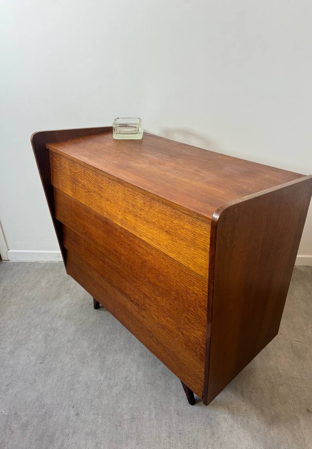 Vintage wooden chest of drawers with tapered legs.