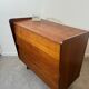 Vintage wooden chest of drawers with tapered legs.