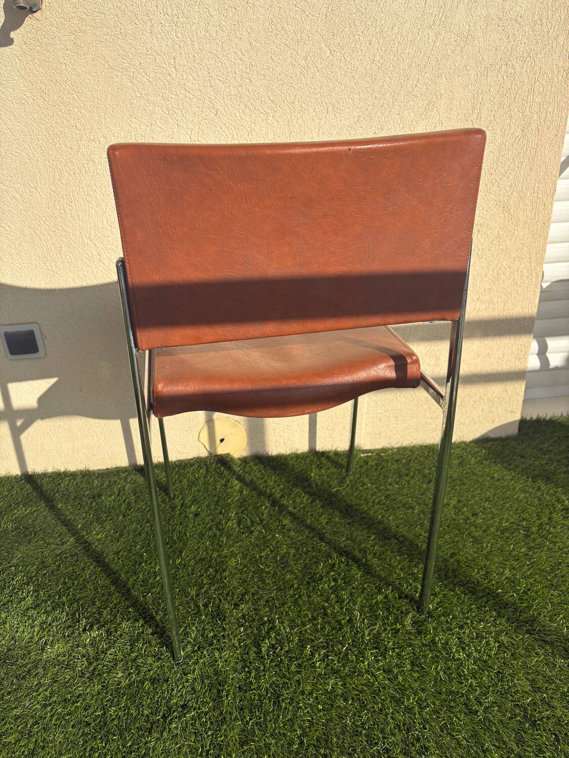 A pair of vintage brown Skaï chairs.