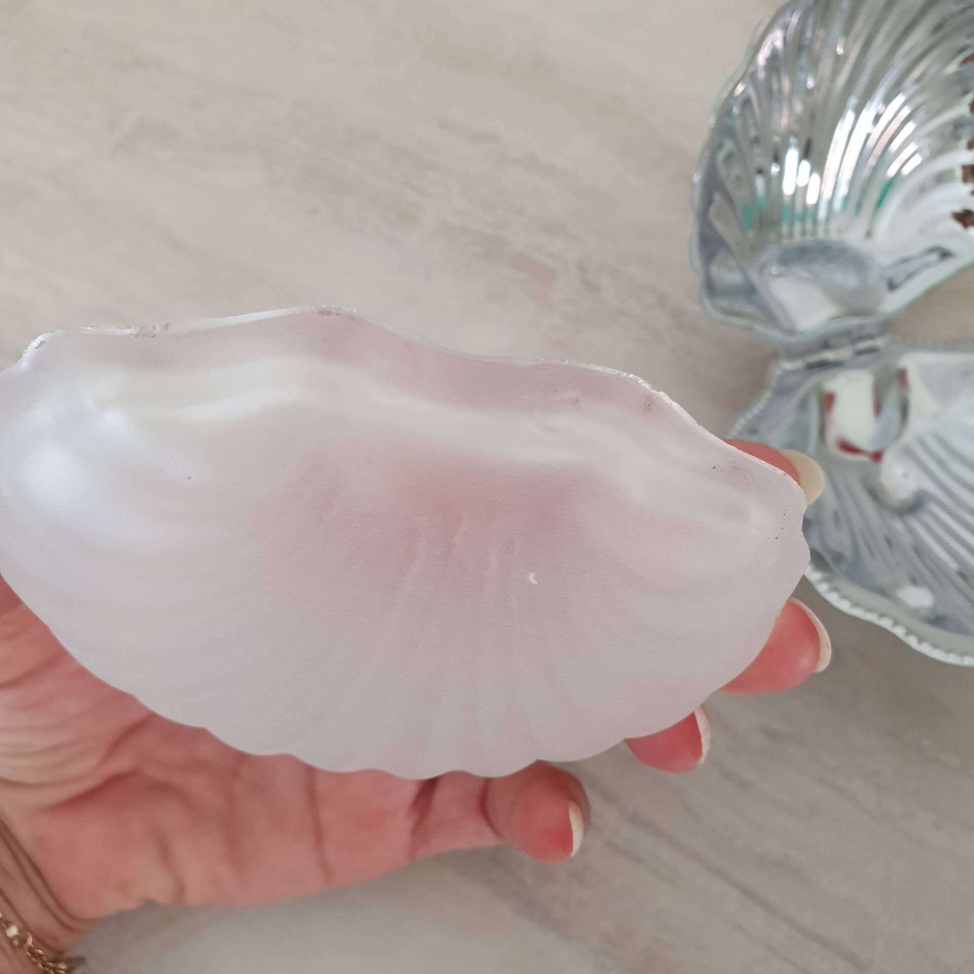 Shell-shaped butter dish in stainless steel and white glass bowl.