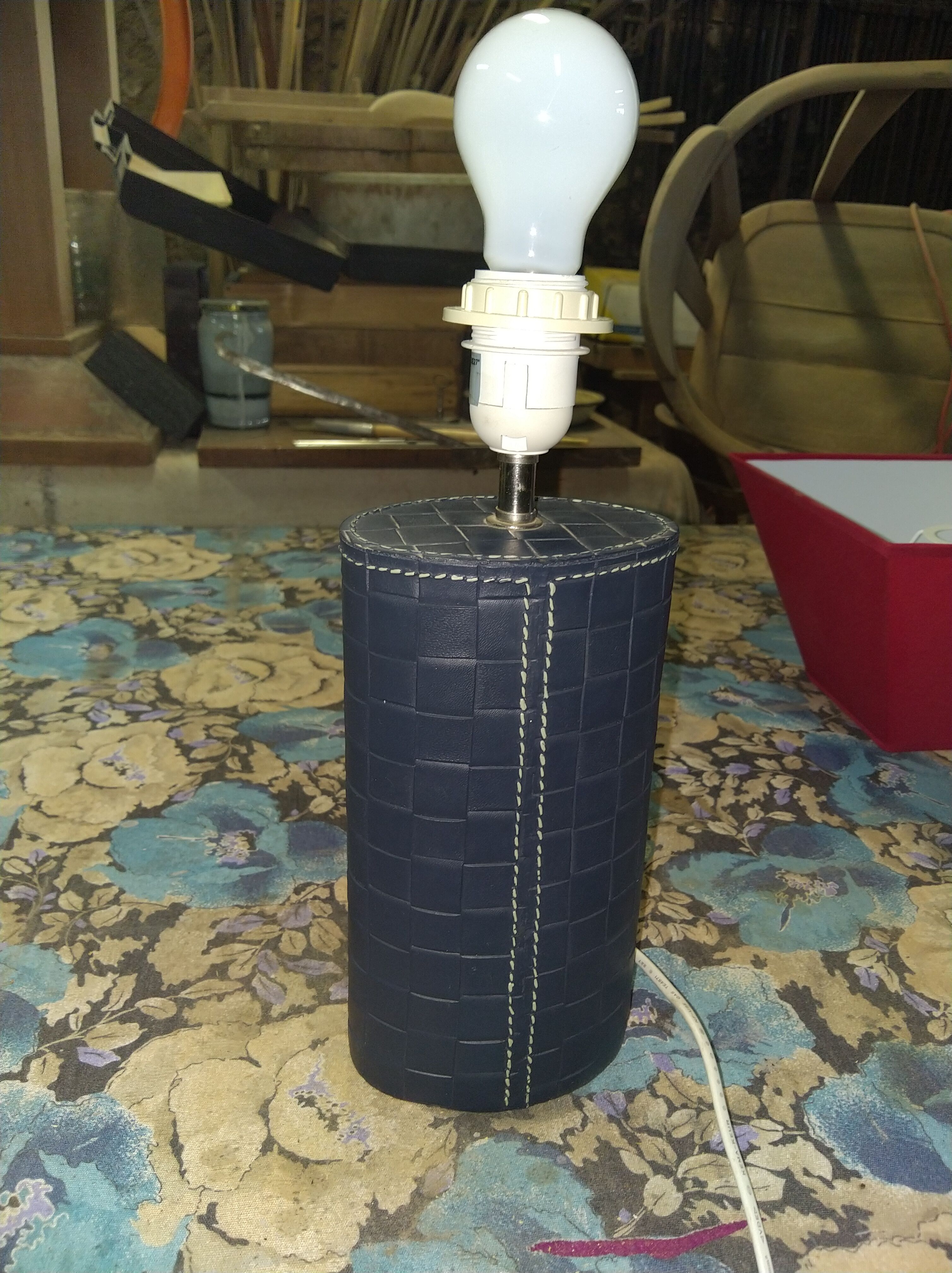Ovoid lamp sheathed in braided blue leather and saddle stitching