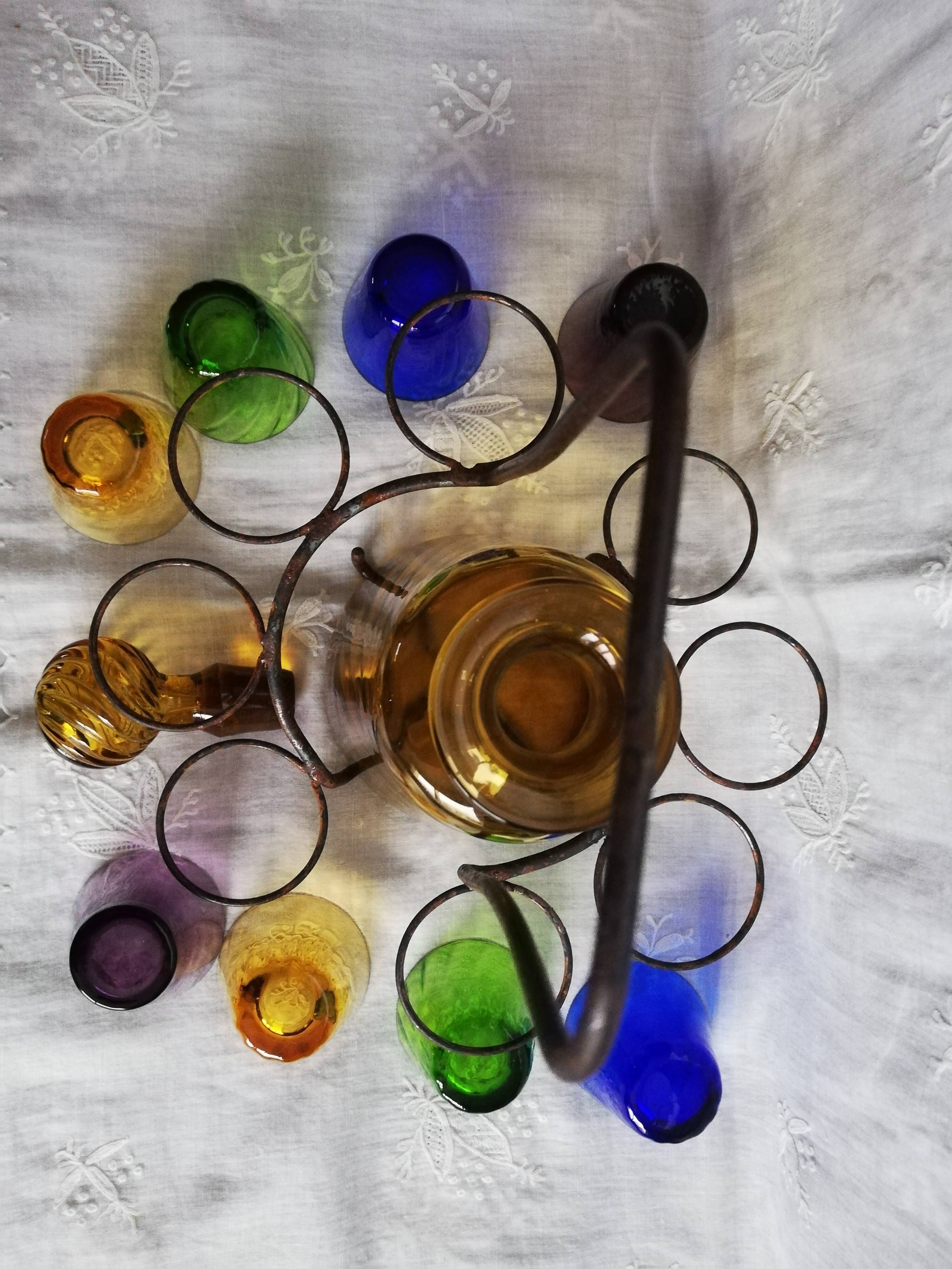 Old Italian alcohol decanter and its colorful glasses