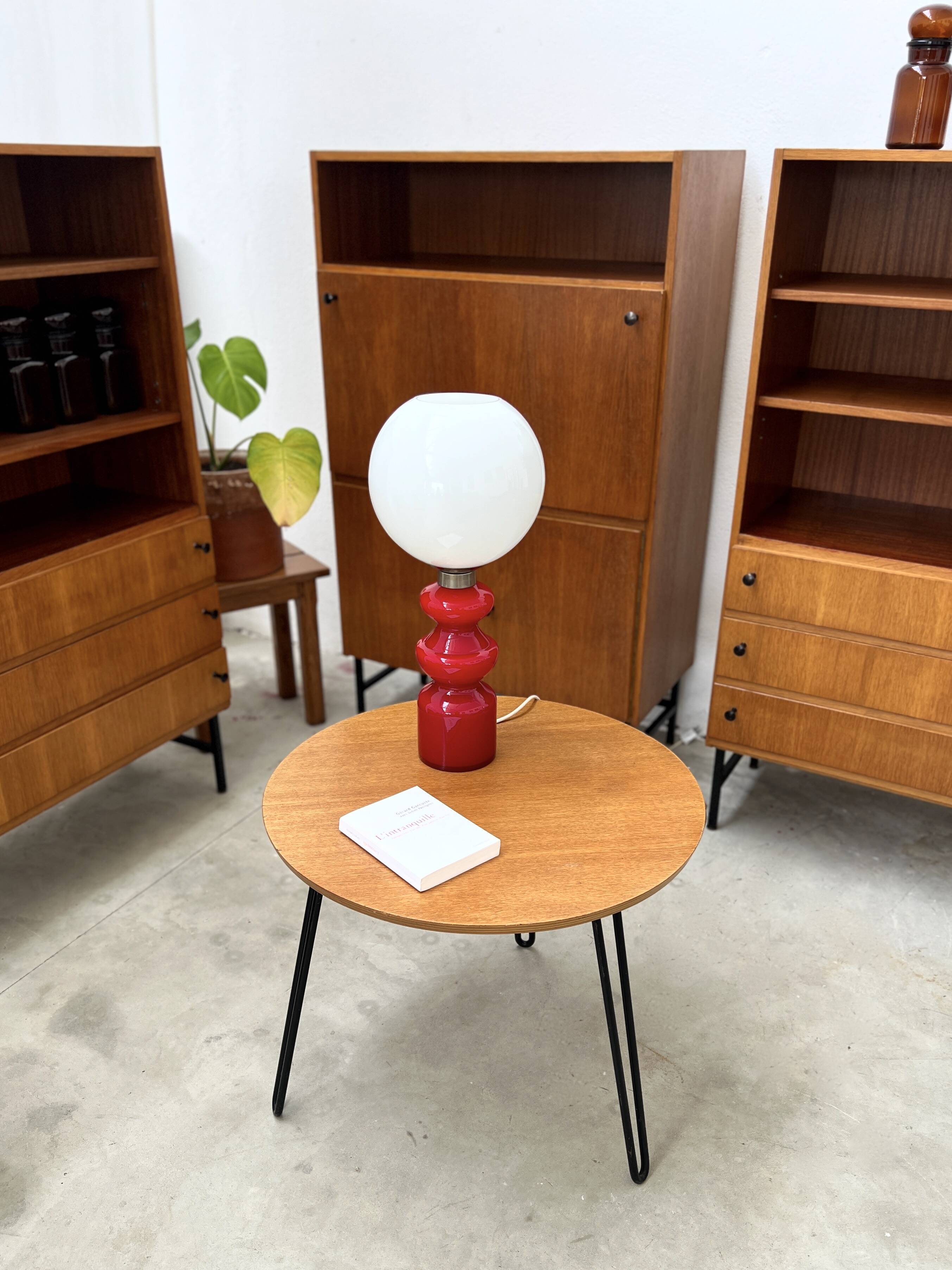 Round side table with black lacquered metal hairpin legs.