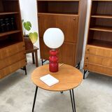 Round side table with black lacquered metal hairpin legs.