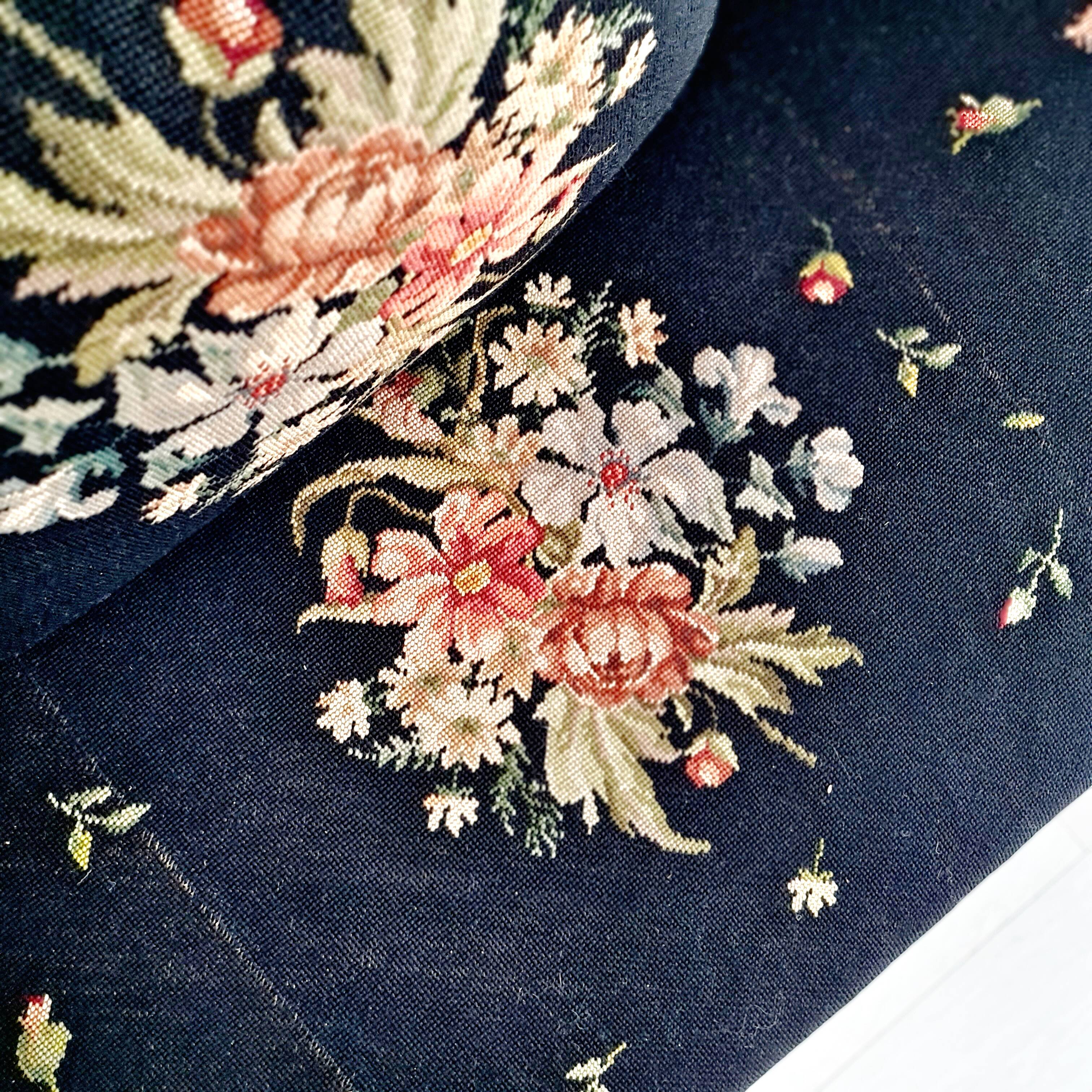 Old bench upholstered in black canvas flowers