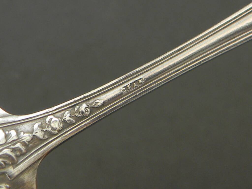 Set of 11 SFAM silver metal teaspoons.