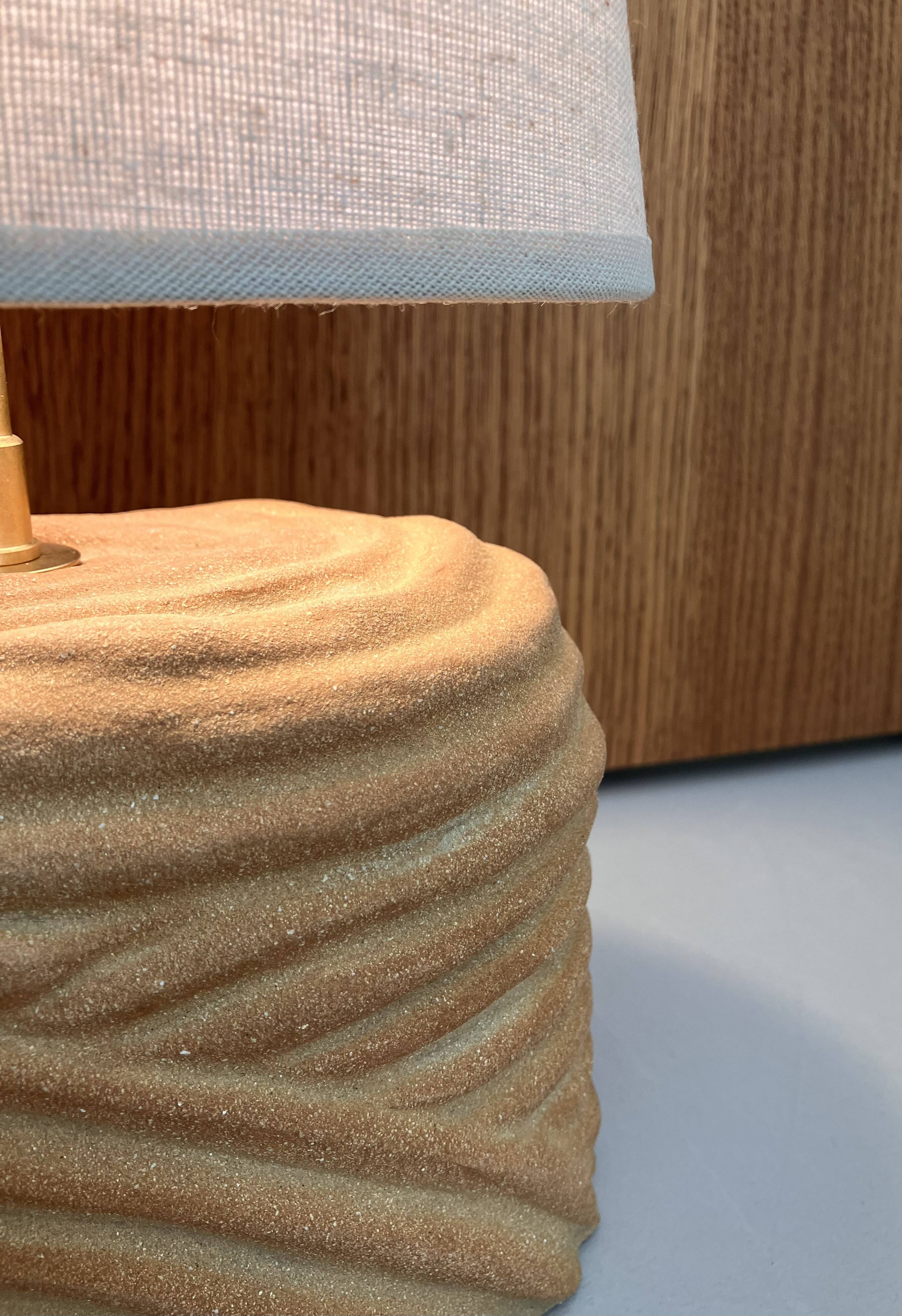 Oval table lamp in handcrafted ceramic with draped effect.