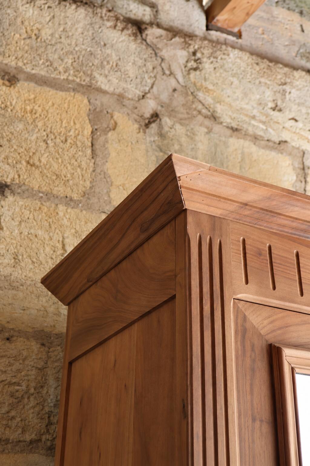 Antique walnut bonnetière with bevelled mirror.