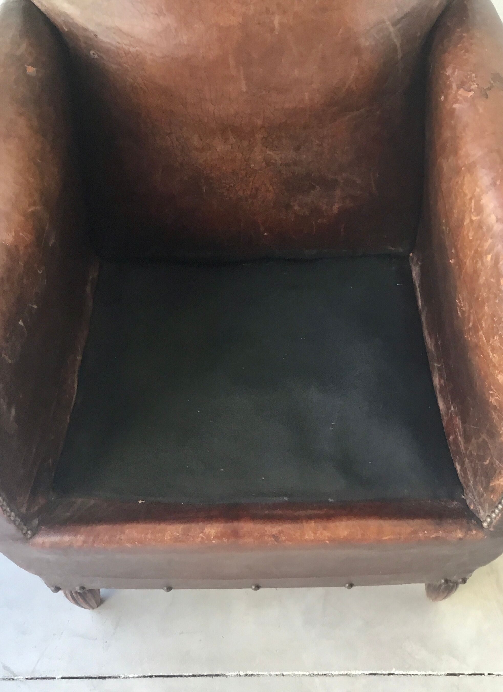 Club armchair in studded leather - early twentieth century