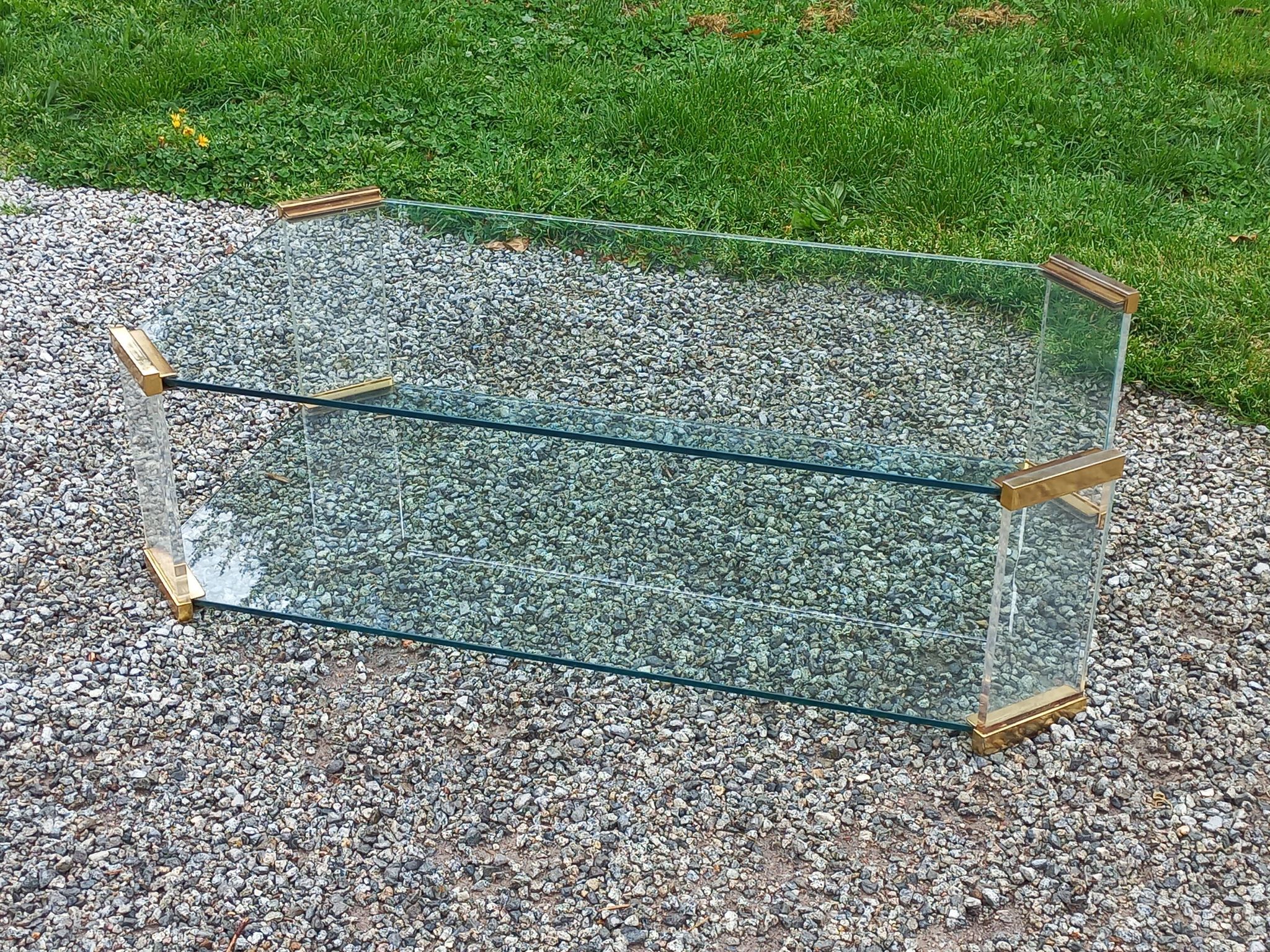 1970s designer coffee table in glass, plexiglass, and gold metal.
