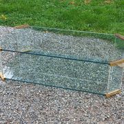 1970s designer coffee table in glass, plexiglass, and gold metal.