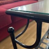 Coffee table with a glass top and black metal frame.